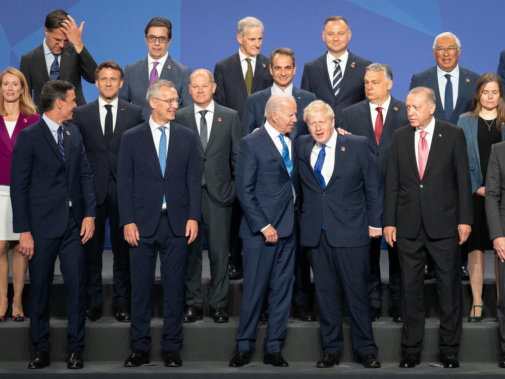 British Prime Minister Boris Johnson stands beside President Biden and other world leaders posing for a photo during the NATO summit on Wednesday in Madrid, Spain. The defense alliance declared Russia a direct threat and members are committing to boost troop levels and position heavy equipment along NATO's eastern flank.