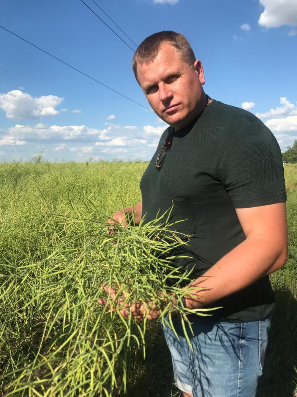 Farmer Oleksandr Tatarov holds some of his rapeseed that he hopes to export for cooking oil. If he cannot sell this year's harvest, he'll store the seeds in silo bags in his field. The night before this photo was taken, Russian shelling destroyed one of his storage facilities.