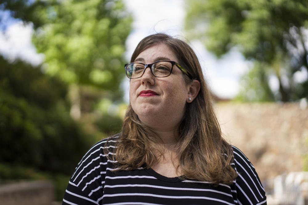 Kristin Zawatski, a training project manager, stands outside the Feldberg Communications building at Brandeis University in Waltham, Mass., on June 28.