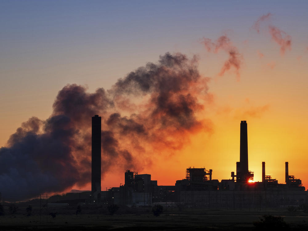 In this July 27, 2018 photo, the Dave Johnson coal-fired power plant is silhouetted against the morning sun in Glenrock, Wyo.