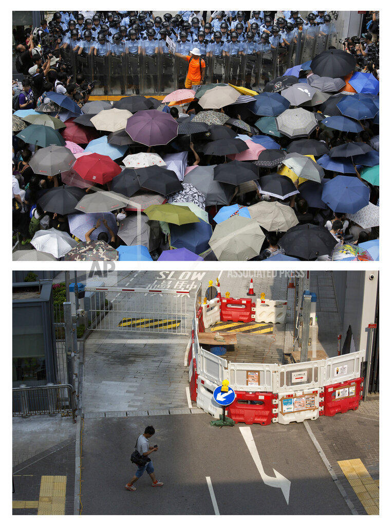 This combination of Sept. 27, 2014 (top) and Sept. 26, 2015 photos shows a protester holding a placard that reads 