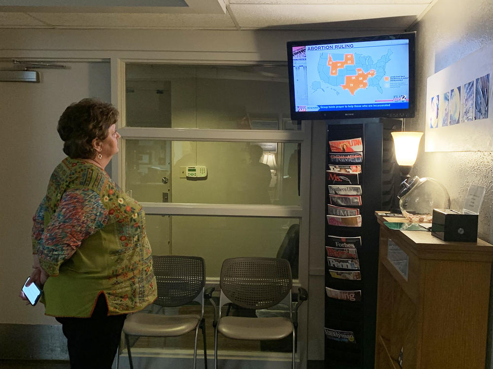 Kathaleen Pittman, administrator at Hope Medical Group in Shreveport, watches local TV news discussing a temporary restraining order the clinic won on Monday against Louisiana's abortion bans.