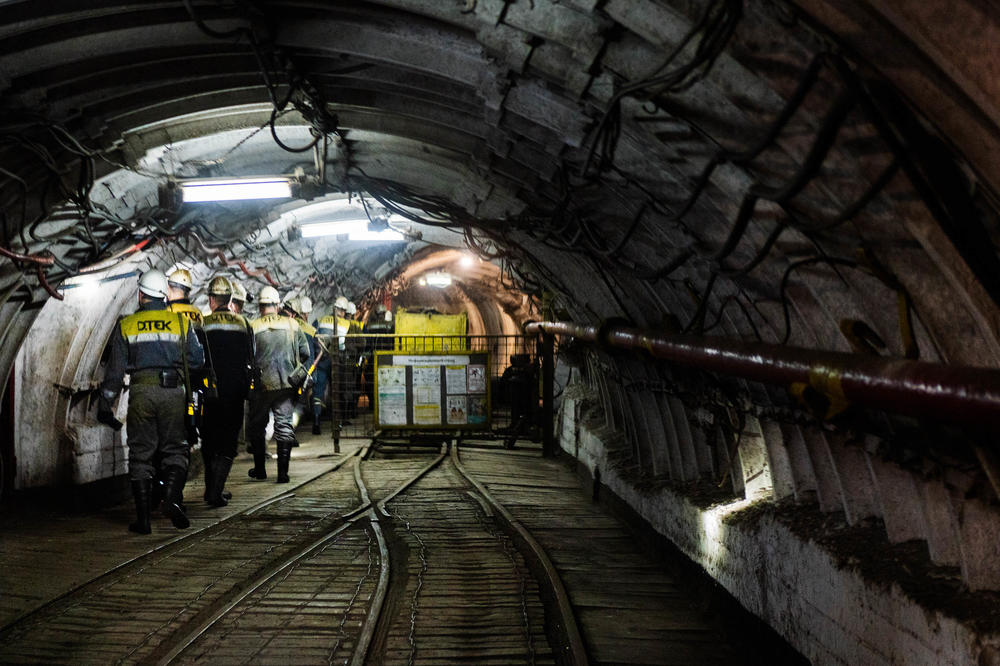 Workers having just gotten off the elevator head deeper into the mine to start their shifts.