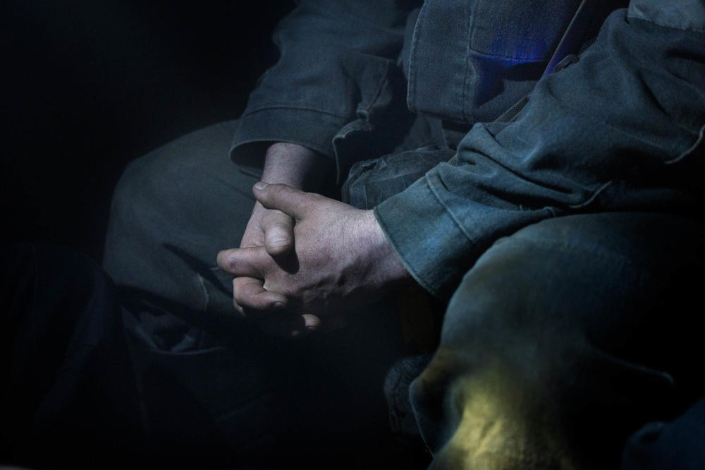 A mine employee folds his hands as he sits in the mine railway awaiting his stop. For miners in eastern Ukraine, who have long watched their industry erode, the shift in rhetoric and renewed focus on coal is being seen as an opportunity.