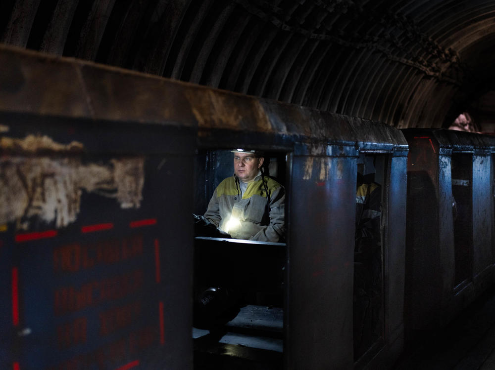 An employee at a coal mine in eastern Ukraine travels deep into the mine.