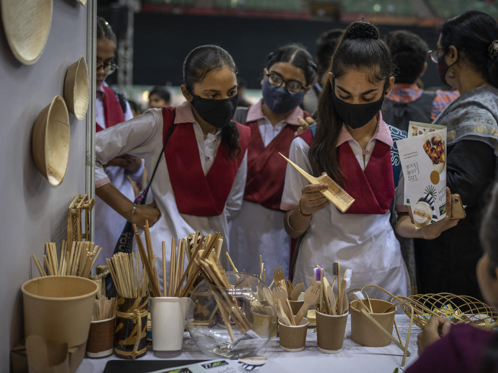 Schoolgirls look at items which are an alternate to plastic at an event to create awareness about eco-friendly products in New Delhi on Friday.