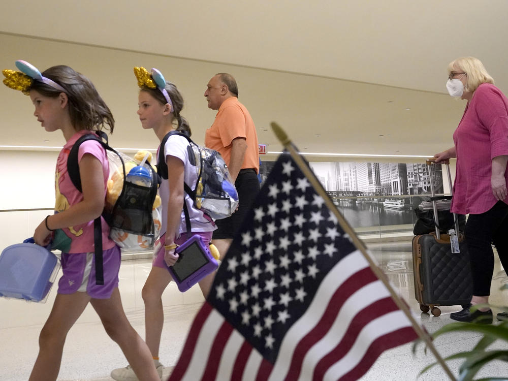 Airline passengers arrive at Chicago's Midway International Airport on the first day of the July Fourth holiday weekend on Friday.