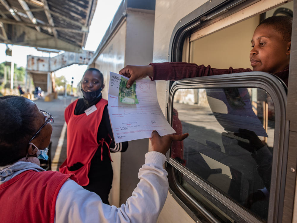 A pharmacist on the Phelophepa health-care train takes payment for a patient's prescription.