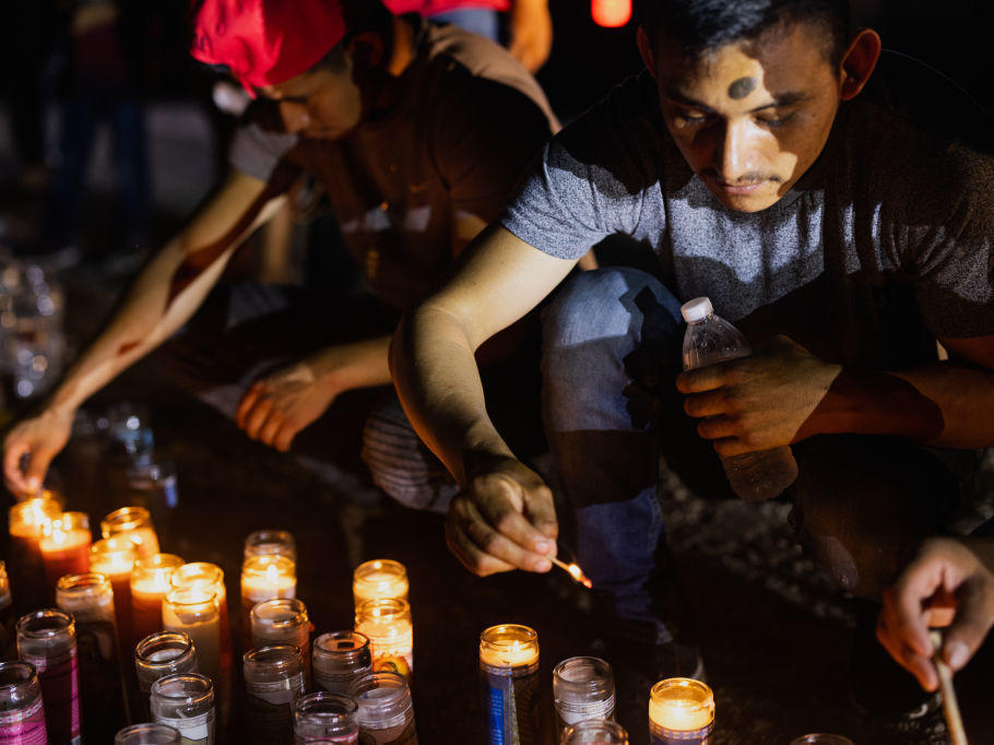 People gather at a makeshift memorial for the 53 migrants who died this week in San Antonio.