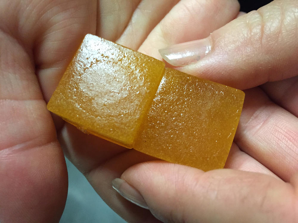 An employee displays a limeade-flavored cannabis-infused gummy candy at the Chalice Farms industrial kitchen in Portland, Ore., in June 2016.