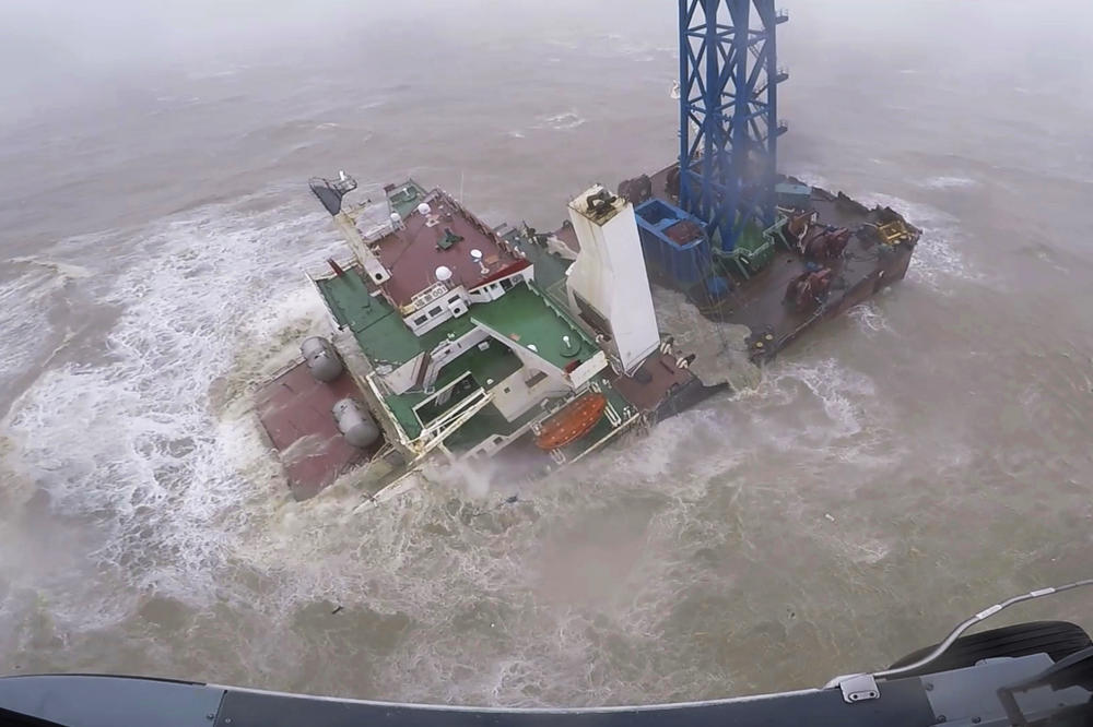 A helicopter with rescue crew members approaches a sinking ship in the South China Sea on Saturday.