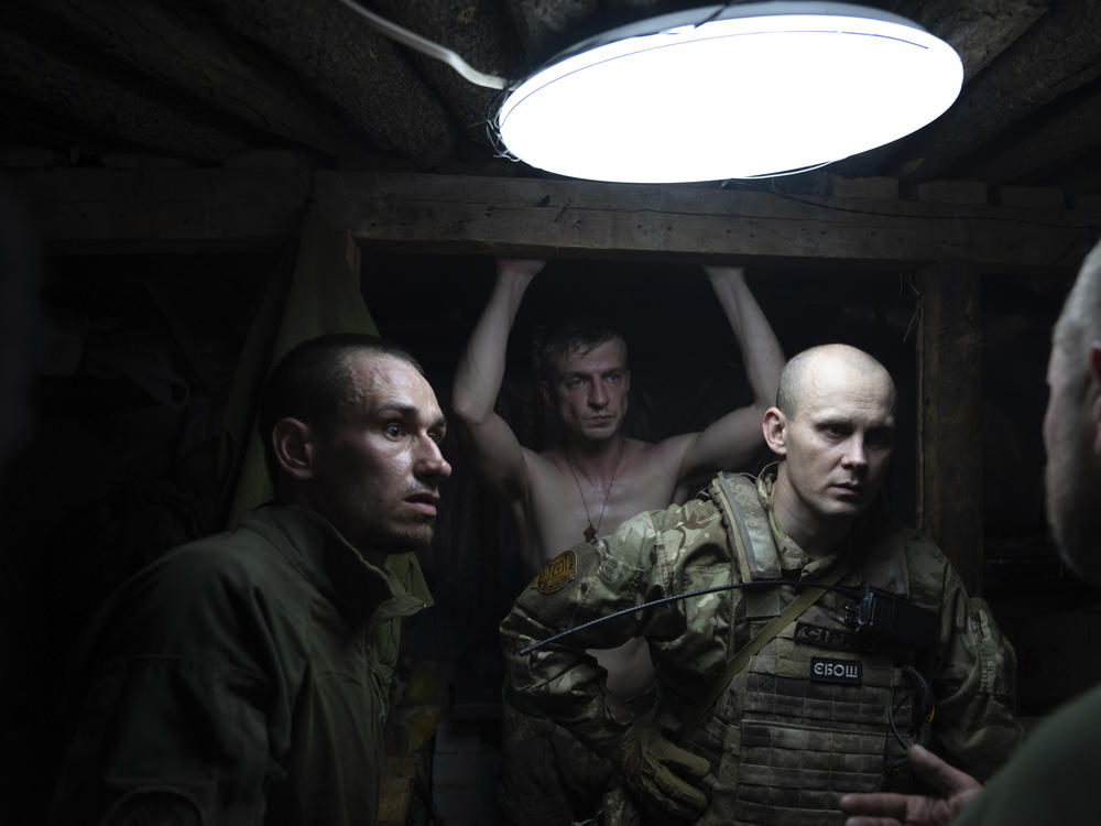 Ukrainian servicemen speak in the shelter at their position at the frontline near Kharkiv, Ukraine, on Saturday, July 2, 2022.