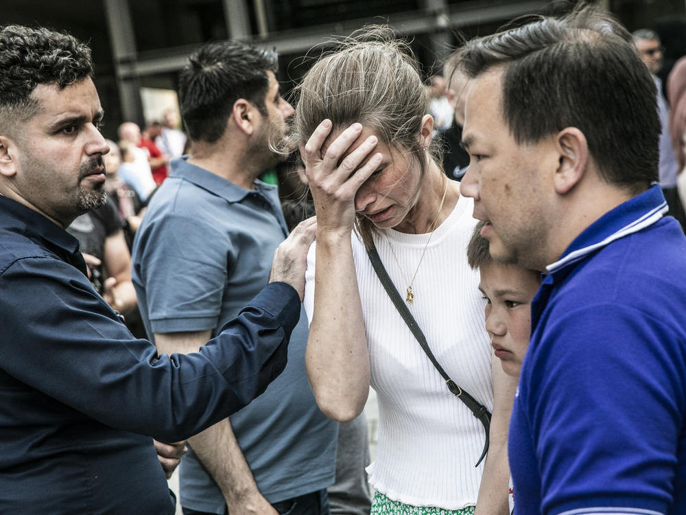 People react in front of the Field's shopping center in Copenhagen, Denmark Sunday, July 3, 2022. A gunman opened fire inside the busy shopping mall in the Danish capital Sunday.