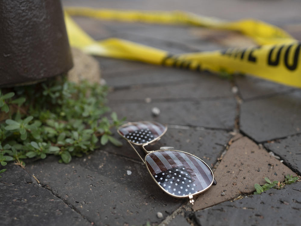 Police crime tape is seen near an American flag-themed sunglasses at the scene of the Fourth of July parade shooting in Highland Park, Ill.