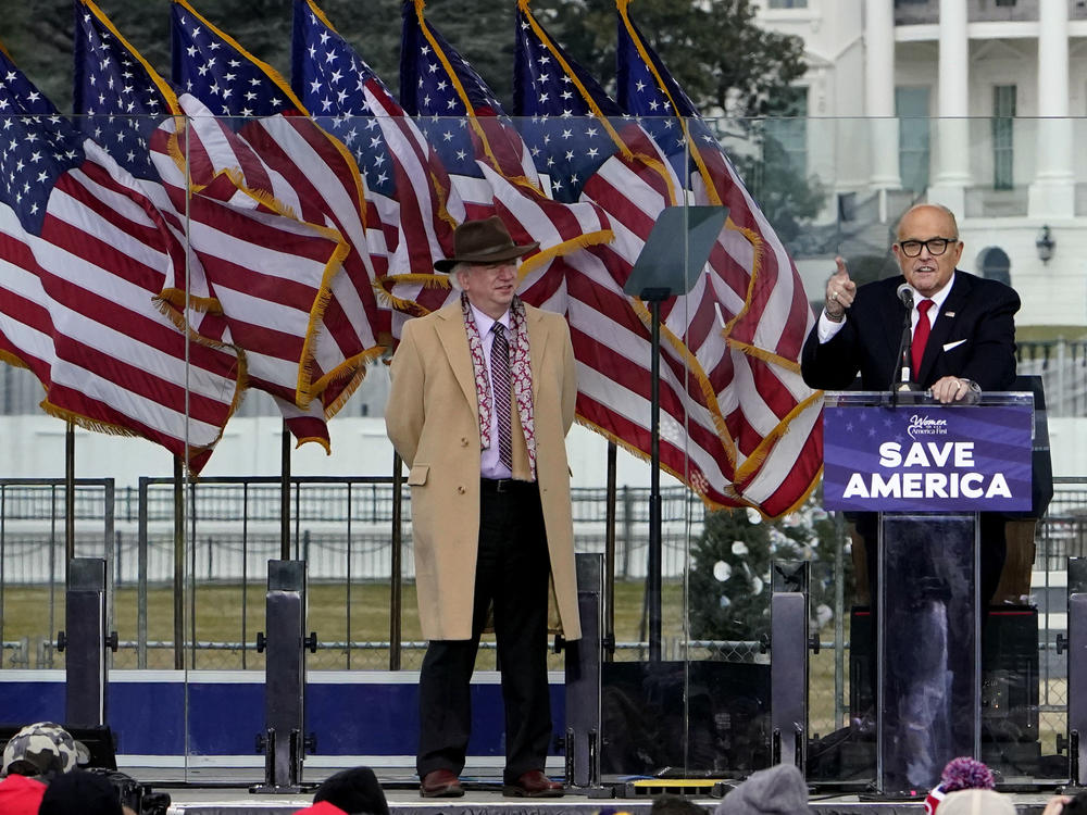 John Eastman, attorney for former President Donald Trump, stands at left as Rudy Giuliani speaks in Washington at a rally in support of Trump.
