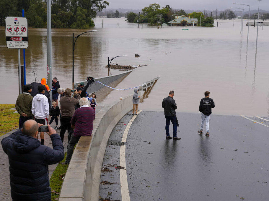 People look Tuesday at the flooded Windsor Bridge at Windsor on the outskirts of Sydney, Australia.