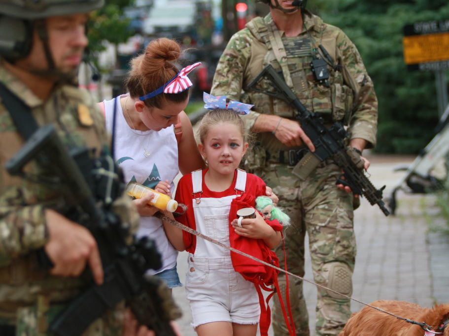 Law enforcement escorts a family away from the scene of a shooting at a parade on July 4 in Highland Park, Ill.