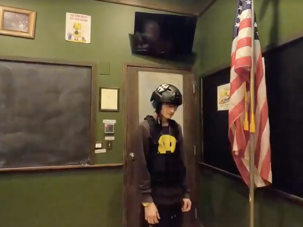 Crimo made rap music under the name Awake The Rapper. In one video, he wears a helmet and vest inside an empty classroom and scatters bullets across the floor.
