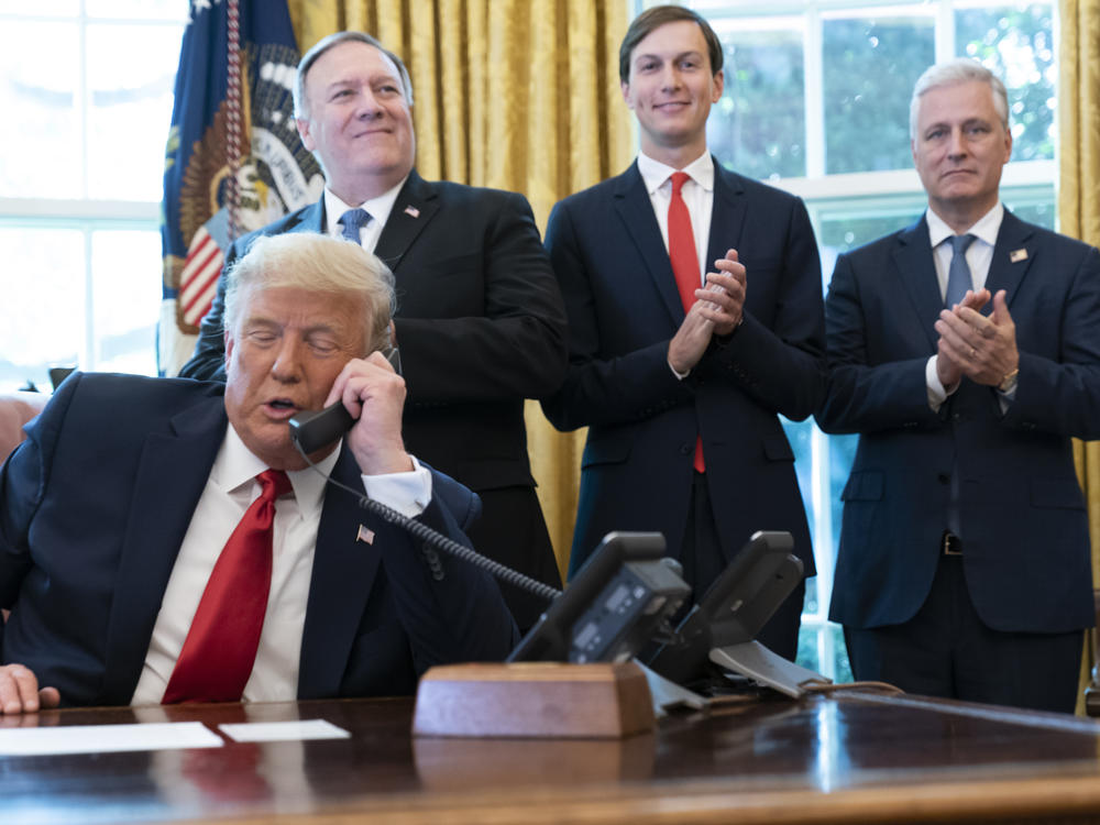 In this 2020 file photo, former President Donald Trump speaks with the leaders of Sudan and Israel by phone, as his foreign policy advisers applaud.