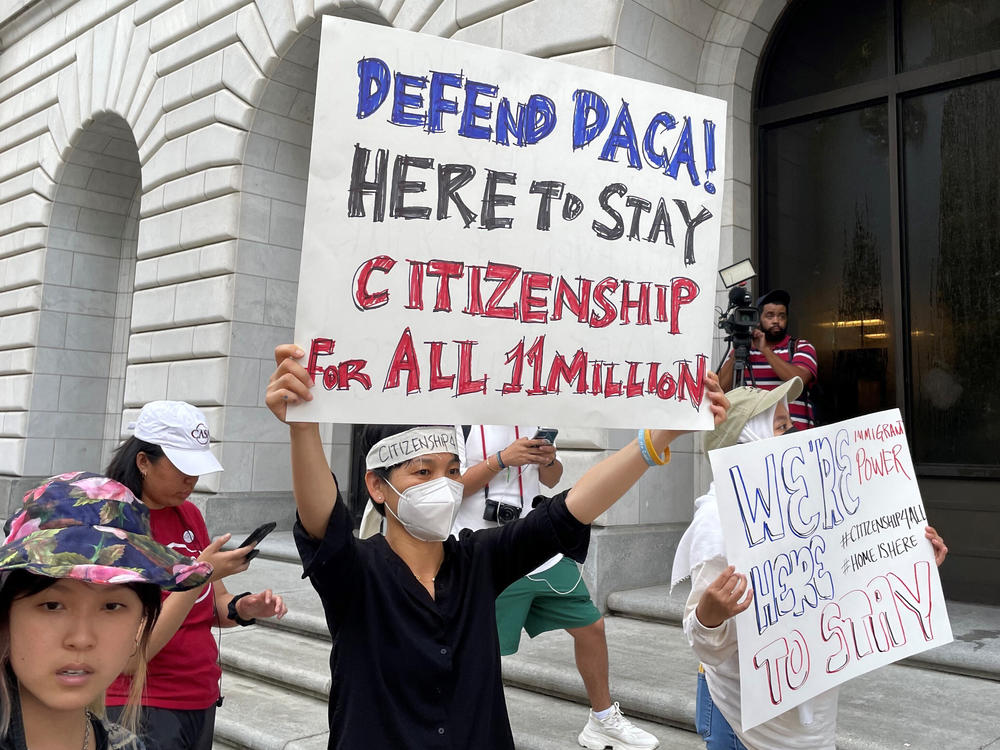 Demonstrators hold up signs outside the 5th U.S. Circuit Court of Appeals building in New Orleans on Wednesday as a panel of judges heard arguments on the Obama-era program that prevents the deportation of thousands of immigrants brought into the U.S. as children.