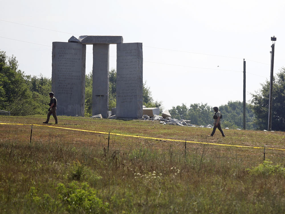Law enforcement officials walk around the damaged Georgia Guidestones monument near Elberton, Ga., on Wednesday.