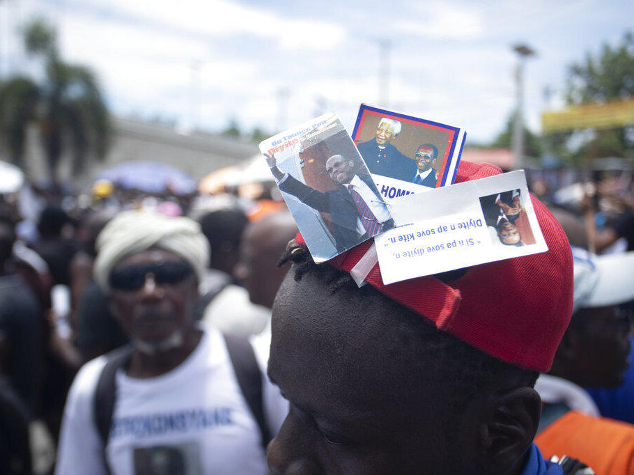 A supporter of former Haitian President Jean-Bertrand Aristide wears stickers of him and late South African President Nelson Mandela on June 26 during a march in Port-au-Prince, Haiti. The demonstrators are asking Aristide to get involved in finding a solution for the current situation of political chaos and lawlessness that is engulfing the Caribbean nation.