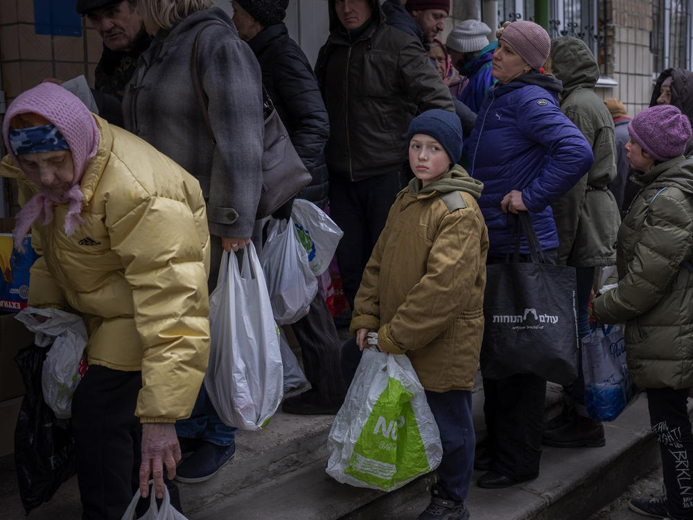 Sergei, 11, waits his turn to receive donated food during an aid humanitarian distribution in Bucha, in the outskirts of Kyiv, on Tuesday, April 19, 2022.