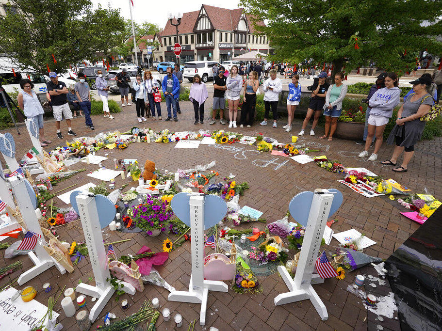 Area residents visit a memorial Wednesday to the seven people who lost their lives in the Highland Park, Ill., Fourth of July mass shooting.
