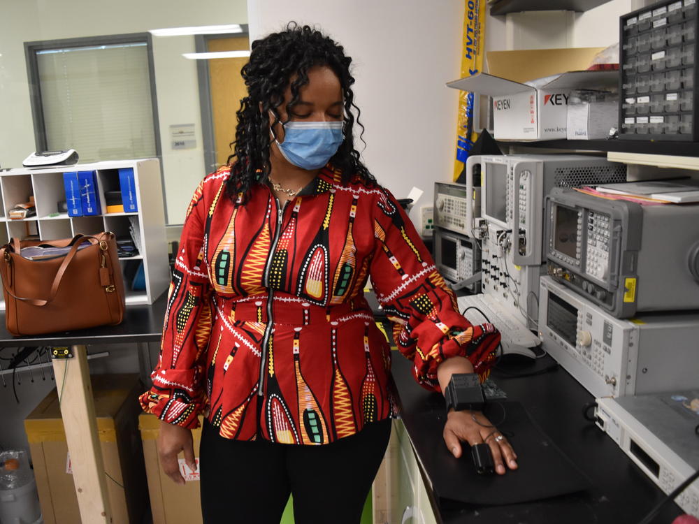 Tufts University associate professor Valencia Koomson, wearing a prototype for a new type of pulse oximeter her lab has patented, which takes a person's skin tone into account.