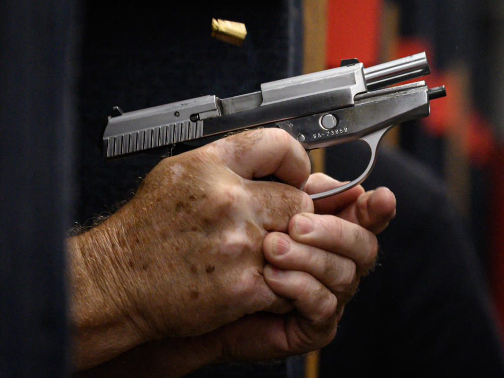 Shooting range owner John Deloca fires his pistol at his range in Queens, N.Y.