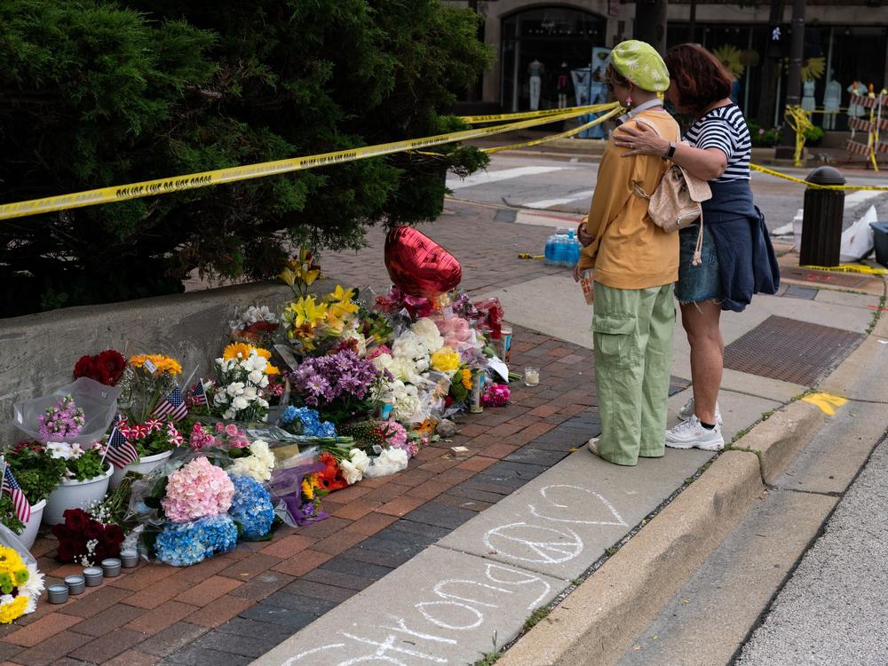 Residents visit a makeshift memorial for victims of the 4th of July mass shooting in downtown Highland Park, Illinois on Wednesday.