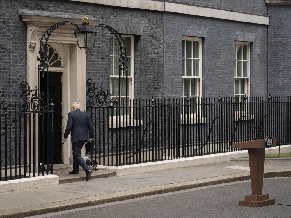 Prime Minister Boris Johnson walks back into 10 Downing St. after announcing his resignation as Conservative Party leader on Thursday.