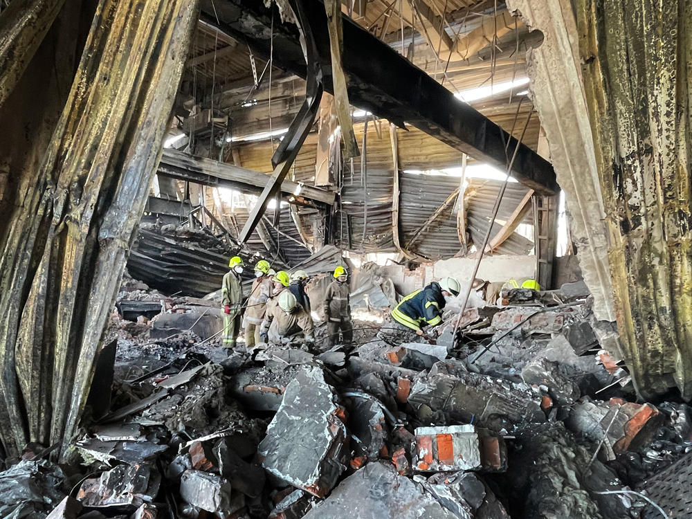 Workers clean up wreckage at the Amstor Mall in Kremenchuk, Ukraine, after the building was hit by a Russian cruise missile.