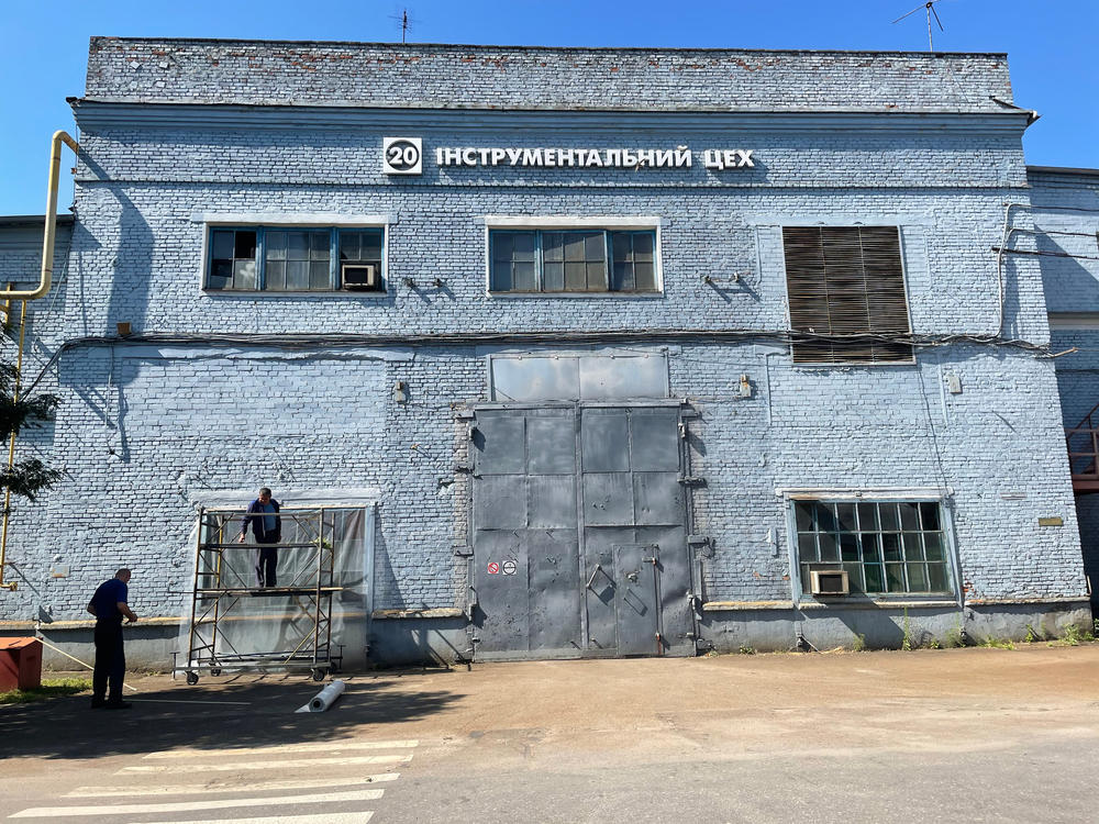 Workers at the Kredmash factory put plastic over windows blown out by the explosion of a Russian cruise missile.