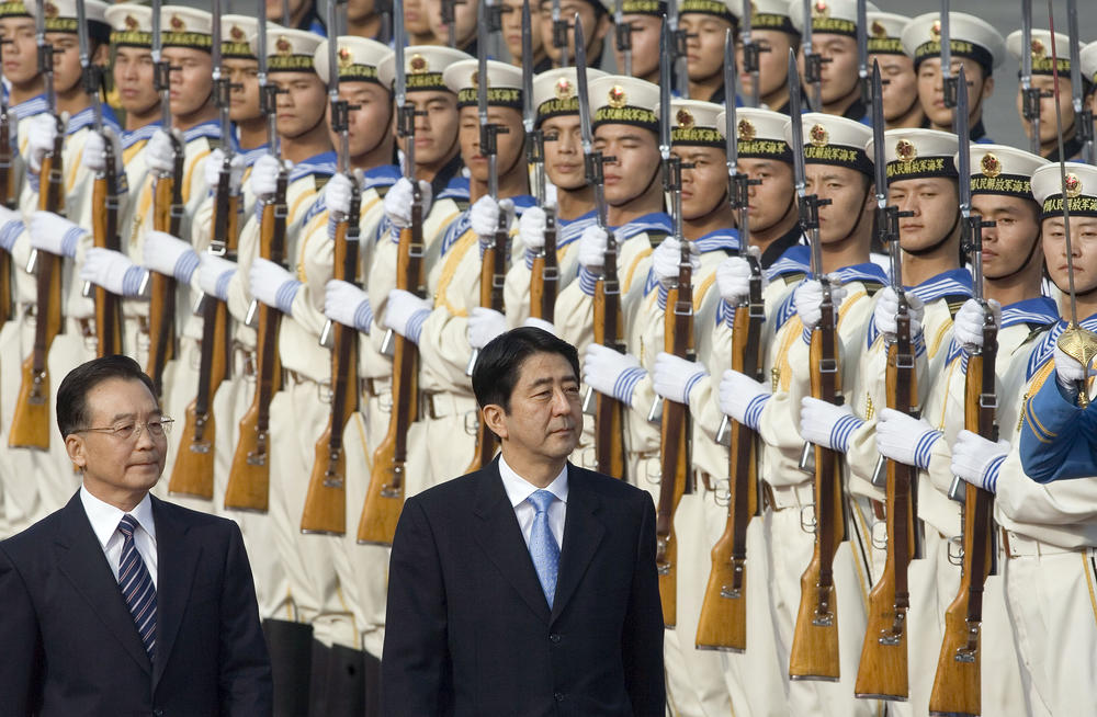 Chinese Premier Wen Jiabao (left), walks with Japanese Prime Minister Shinzo Abe as they inspect a guard of honor during the welcome ceremony held outside the Great Hall of the People in Beijing, Oct. 8, 2006.