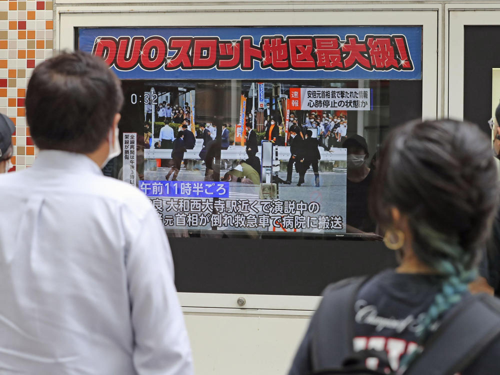 People in Tokyo watch TV news reporting Japan's former Prime Minister Shinzo Abe was shot on Friday.