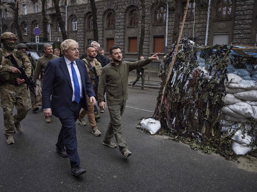 Ukrainian President Volodymyr Zelenskyy, center, and Britain's Prime Minister Boris Johnson walk in downtown Kyiv, Ukraine, in April . Johnson may have been shown the door in Britain, but he remains a popular figure in Ukraine, where he is admired for his support for the country's effort to repel the Russian invasion.