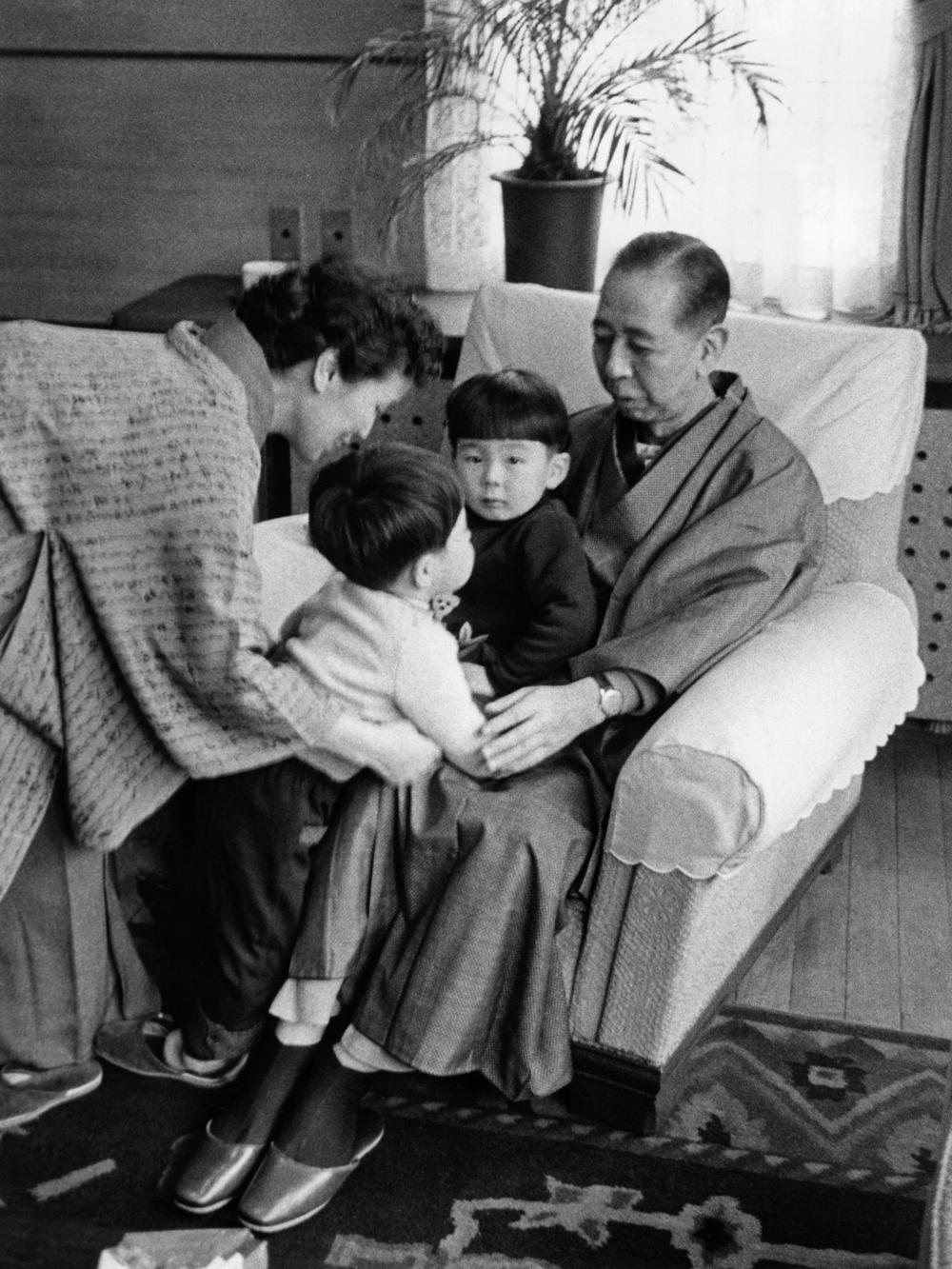 A family picture of Nobusuke Kishi, then-prime minister of Japan, and his wife Ryoko in a kimono, with their grandsons Shinzo Abe and Hironobu Abe (on his grandfather's lap). The photo is undated but is probably taken in the 1960s, likely in the prime minister's official residence in Tokyo.