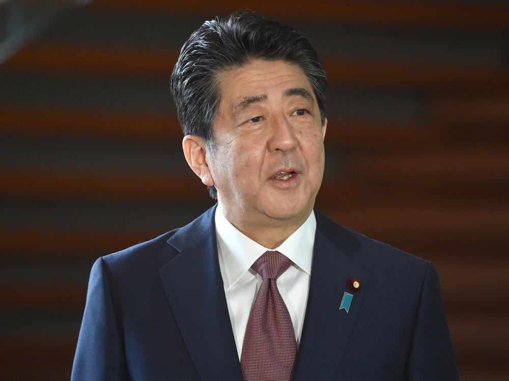 Japan's former Prime Minister Shinzo Abe speaks to the media upon his arrival at his office in Tokyo in 2020.