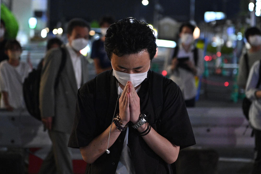 A man prays outside the Yamato-Saidaiji Station in Nara, a city in western Japan, where former Japanese Prime Minister Shinzo Abe was shot earlier in the day Friday.