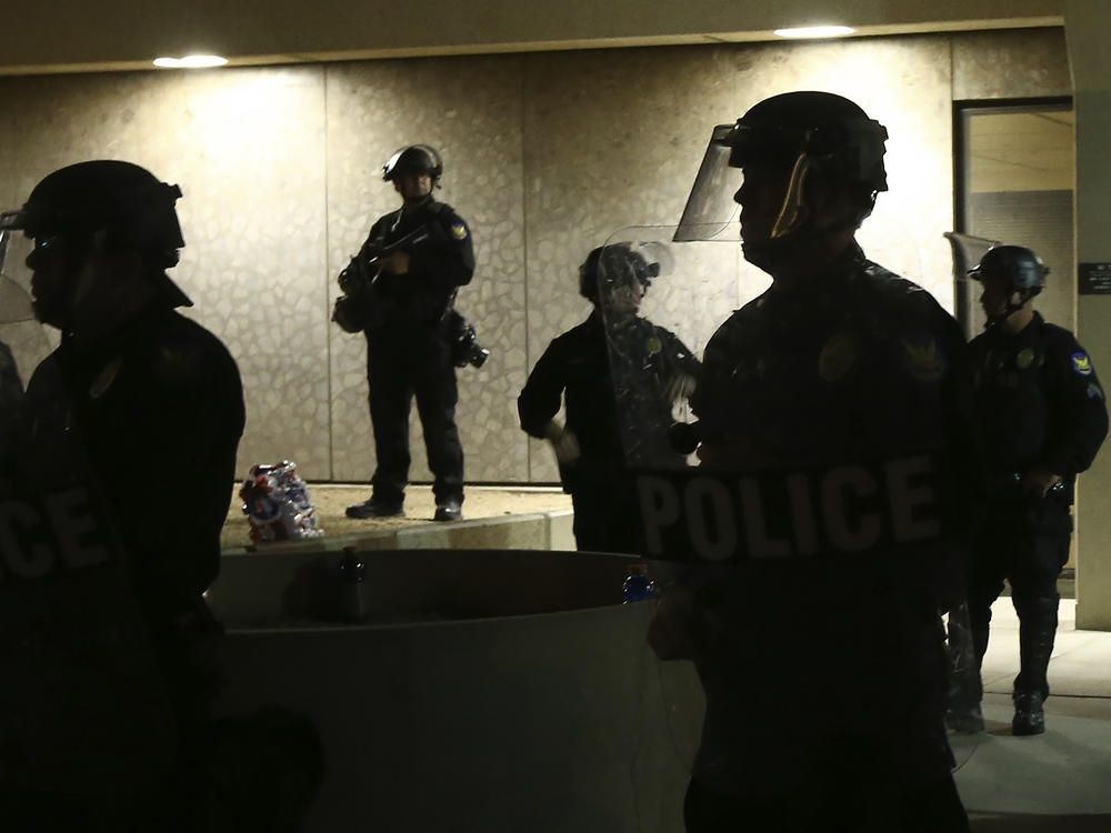 Phoenix police stand in front of police headquarters on May 30, 2020, in Phoenix, waiting for protesters marching to protest the death of George Floyd.