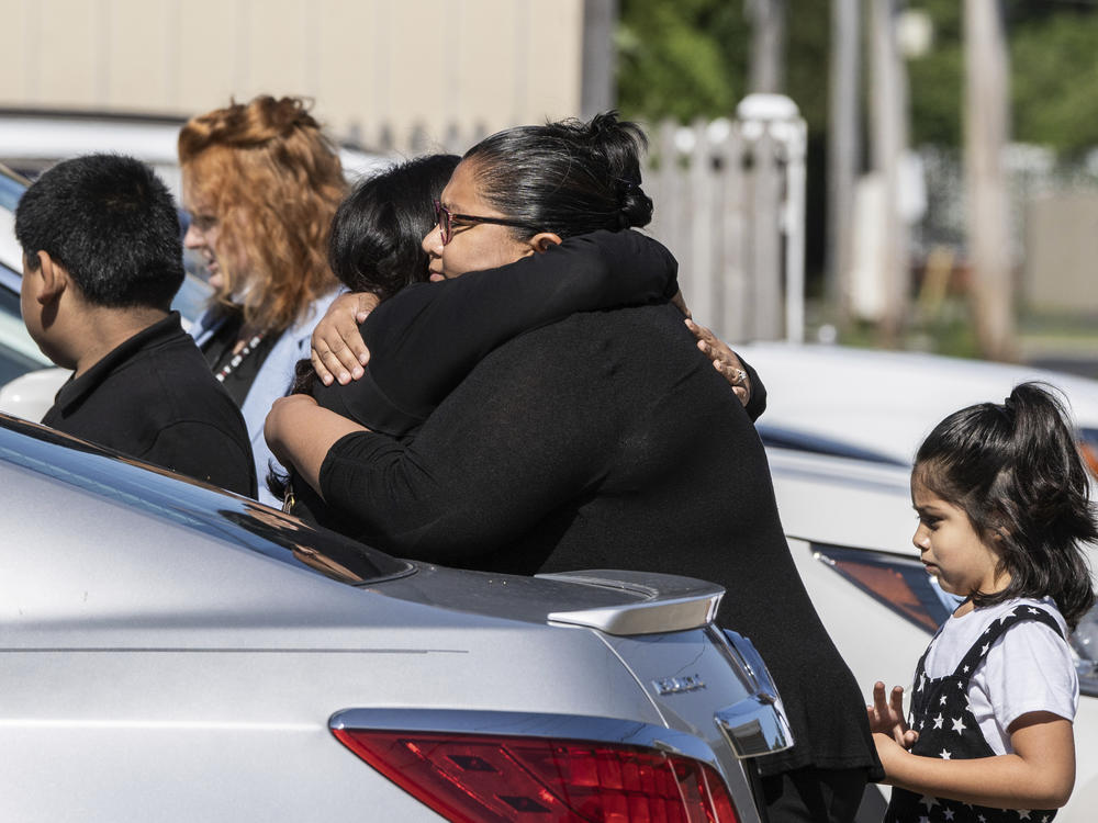 Mourners hug Saturday outside Memorial Chapel Funeral Home in Waukegan, Ill., during funeral services for Eduardo Uvaldo, who was killed Monday during a mass shooting at the Fourth of July parade in Highland Park.