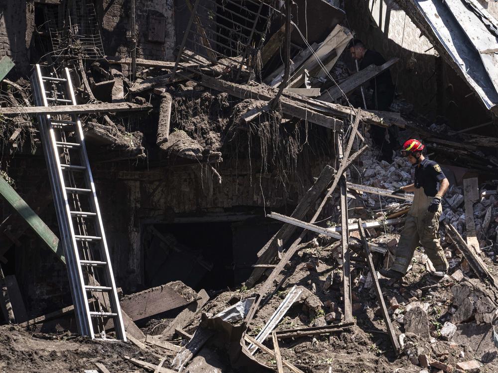 Rescue worker and police officer inspect a site of destroyed house after a Russian attack in a residential neighbourhood in downtown Kharkiv, Ukraine, on Saturday, July 9, 2022. (AP Photo/Evgeniy Maloletka)
