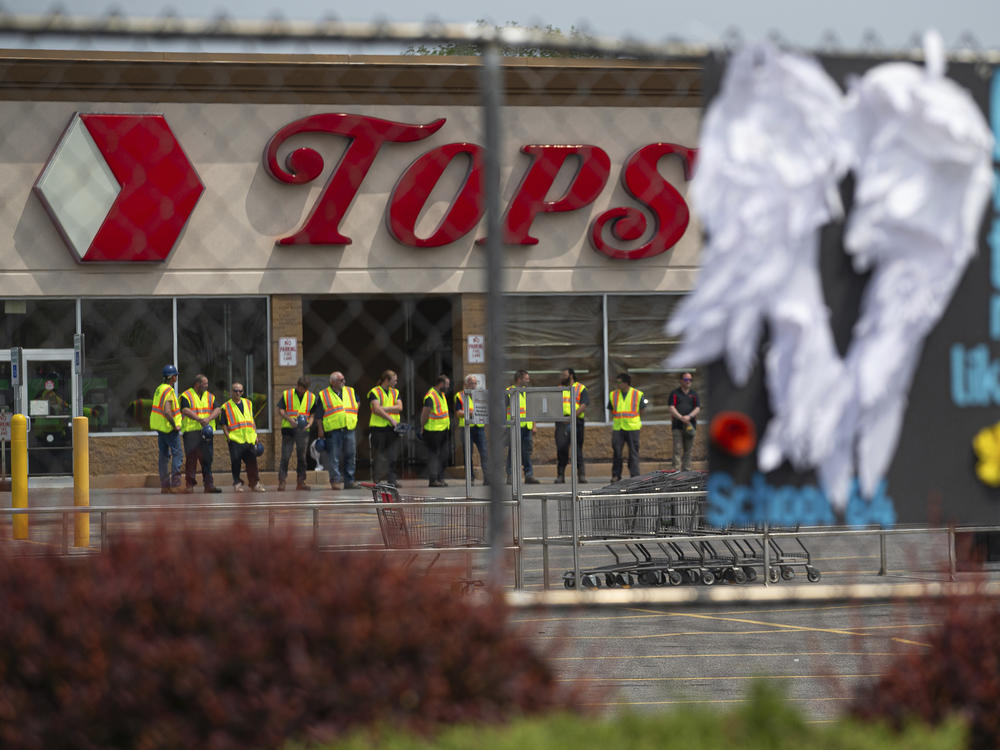 Tops Markets announced Monday that its Buffalo, N.Y. location will reopen on July 15 following the deadly mass shooting in May. Here, investigators stand outside during a moment of silence for the victims of the Buffalo supermarket shooting outside the Tops Friendly Market on Saturday, May 21, 2022.
