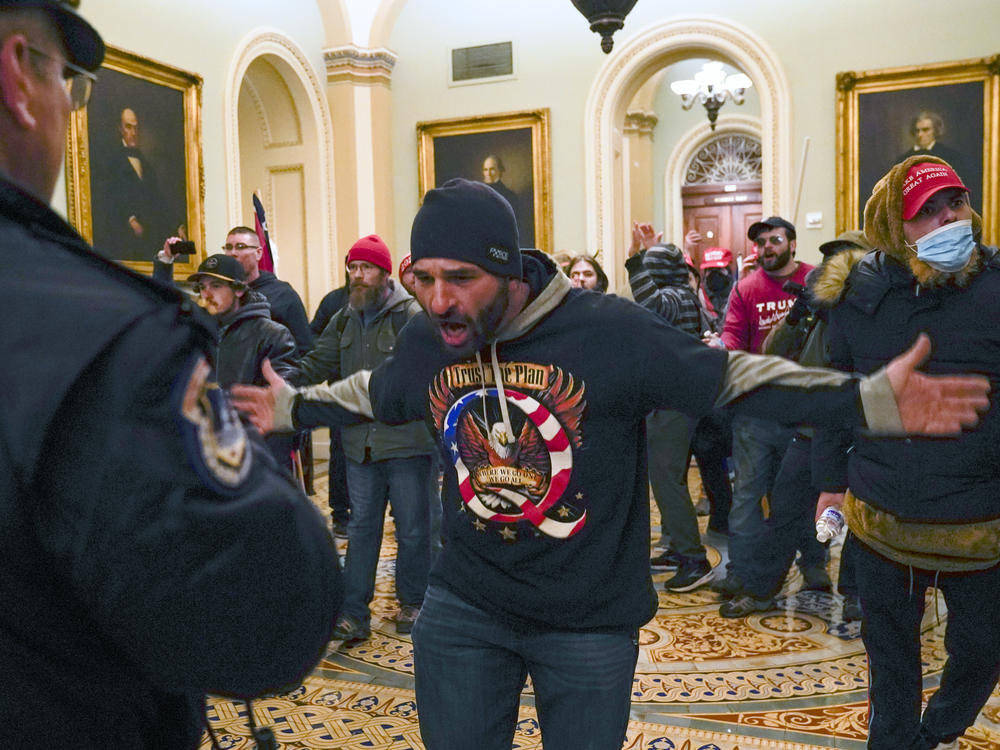 The congressional committee investigating the Jan. 6, 2021 attack on the Capitol will focus on the role of QAnon and extremist groups like the Oath Keepers and Proud Boys in its upcoming hearing. Prosecutors have identified the man at the center of this photograph as a QAnon-supporter named Douglas Jensen. Jensen has pleaded not guilty to all charges.