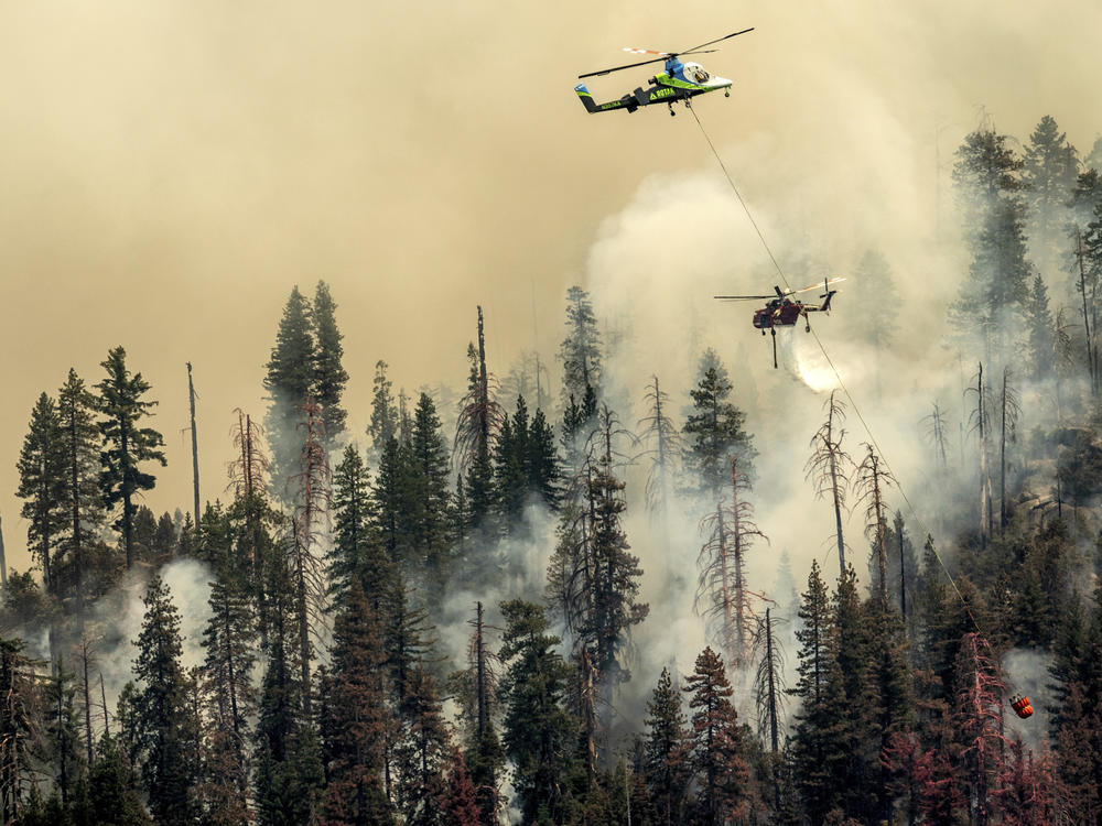 A helicopter drops water on the Washburn Fire burning in Yosemite National Park on Saturday.