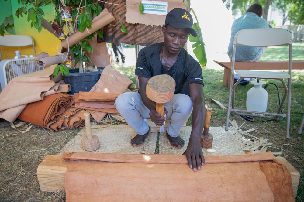 Aloyzius Luwemba, a 10th-generation barkcloth maker, uses a ridged wooden mallet to beat the barkcloth canvas so that it expands in size.
