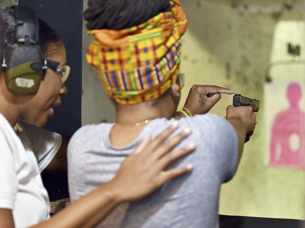 In this May 27, 2017, photo, Marchelle Tigner, a firearms instructor, teaches a student how to shoot a gun during a class in Lawrenceville, Ga. Tigner's goal is to train 1 million women how to shoot a gun in her lifetime. She is among the nation's black women gun owners who say they are picking up firearms for self-protection.