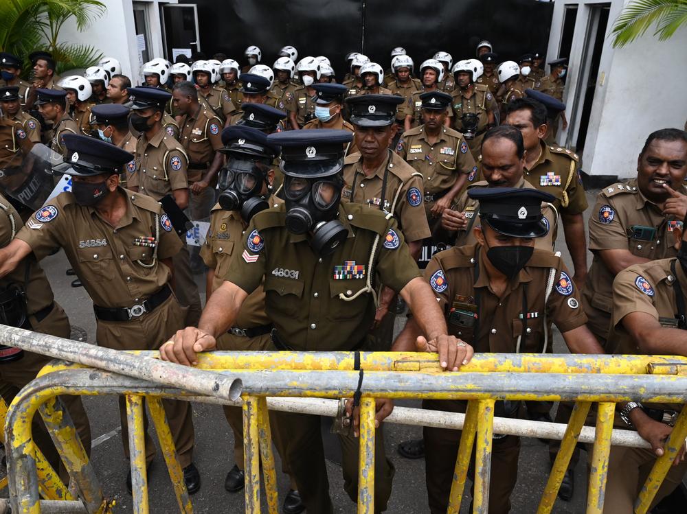 Members of police stand guard in front of the police headquarters during a protest by demonstrators demanding actions against authorities over attacks on protesters and media amid ongoing economic crisis in Colombo on July 11.