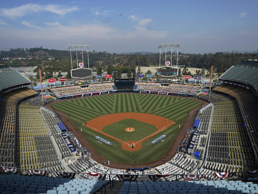 Empty seats and cutouts are viewed in Dodger Stadium as Houston Astros' Lance McCullers Jr. pitches against the Oakland Athletics during the first inning of Game 1 of a baseball American League Division Series in Los Angeles, Oct. 5, 2020. Concession workers at the stadium have voted to authorize a strike days ahead of MLB's All-Star Game festivities in Los Angeles.